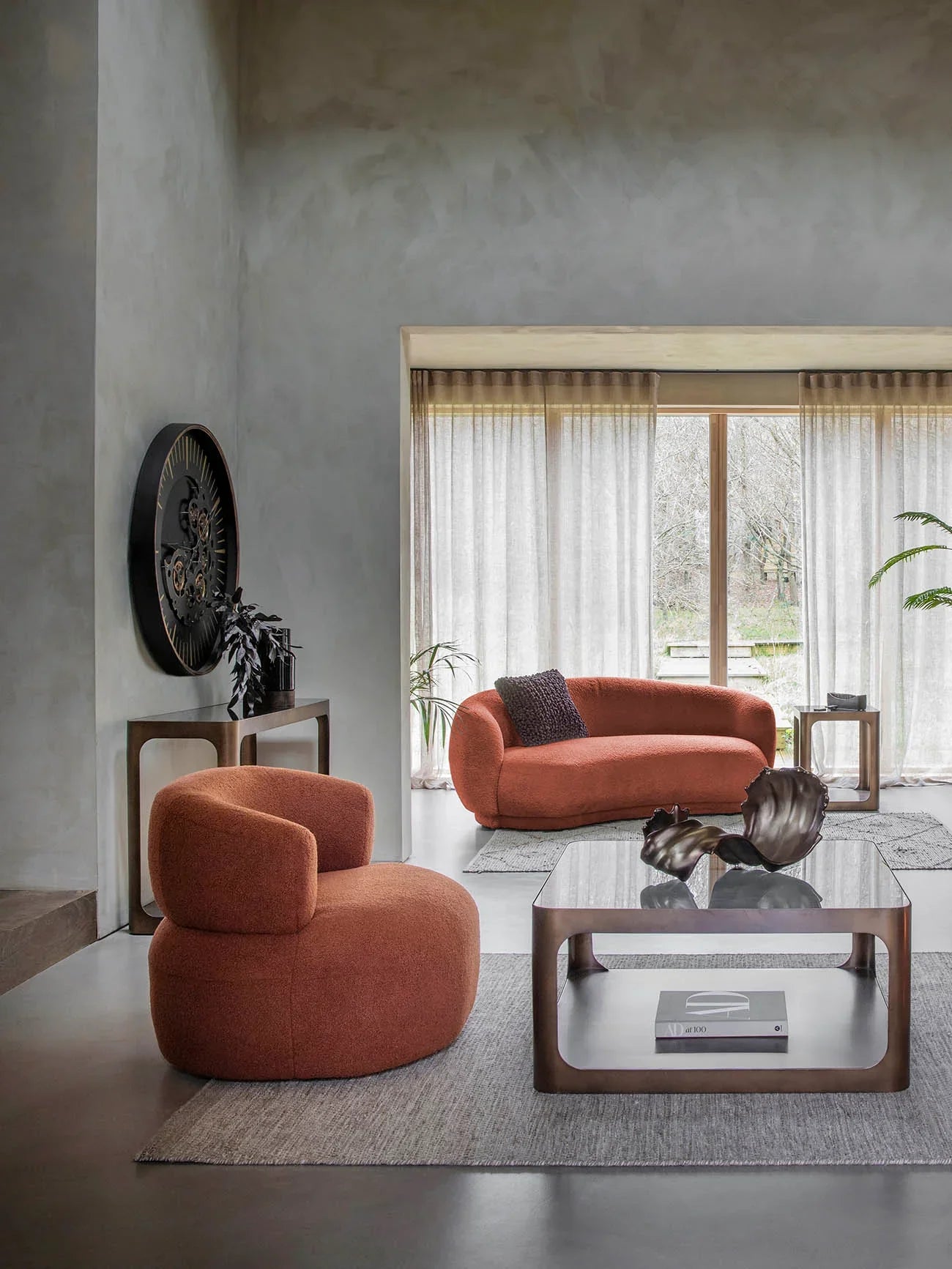 Modern living room with metal and glass side table beside orange sofa.