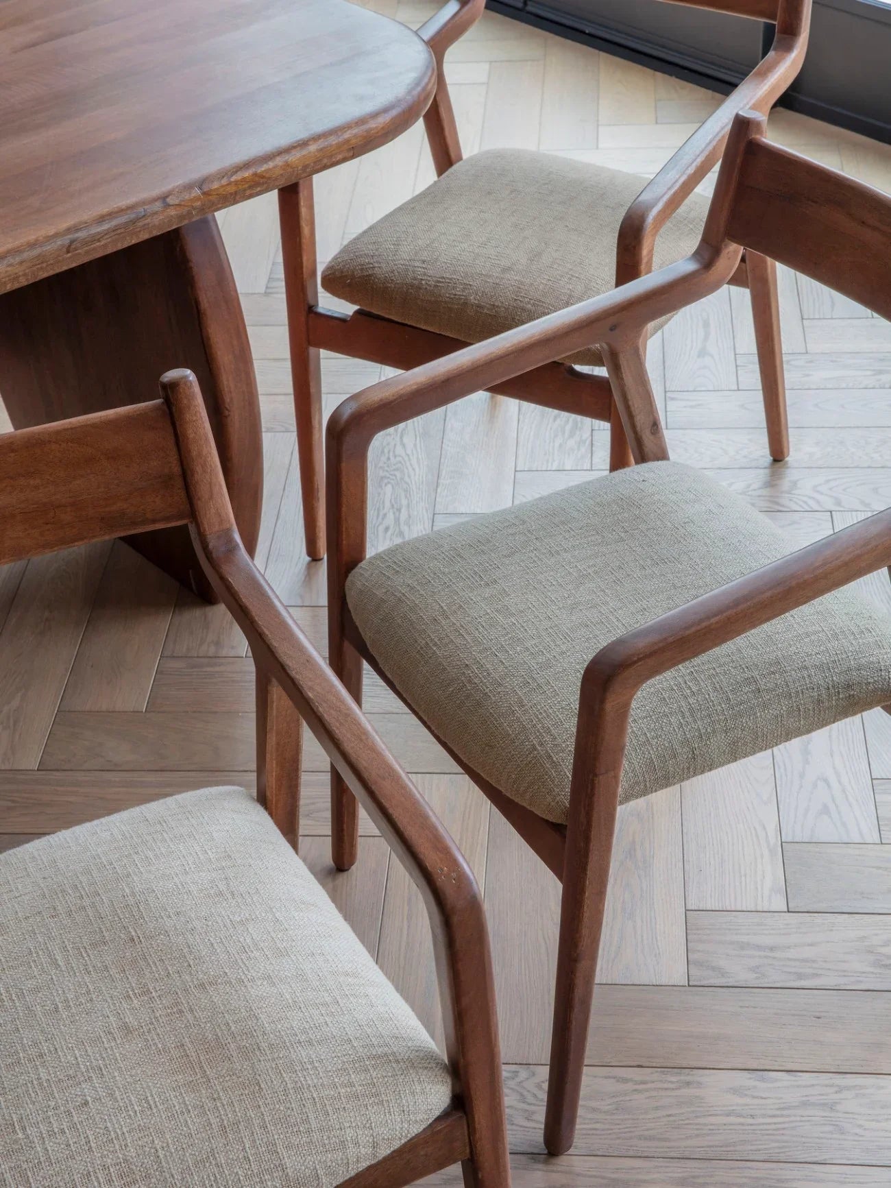 Beige upholstered chairs with wooden frames around a dining table.
