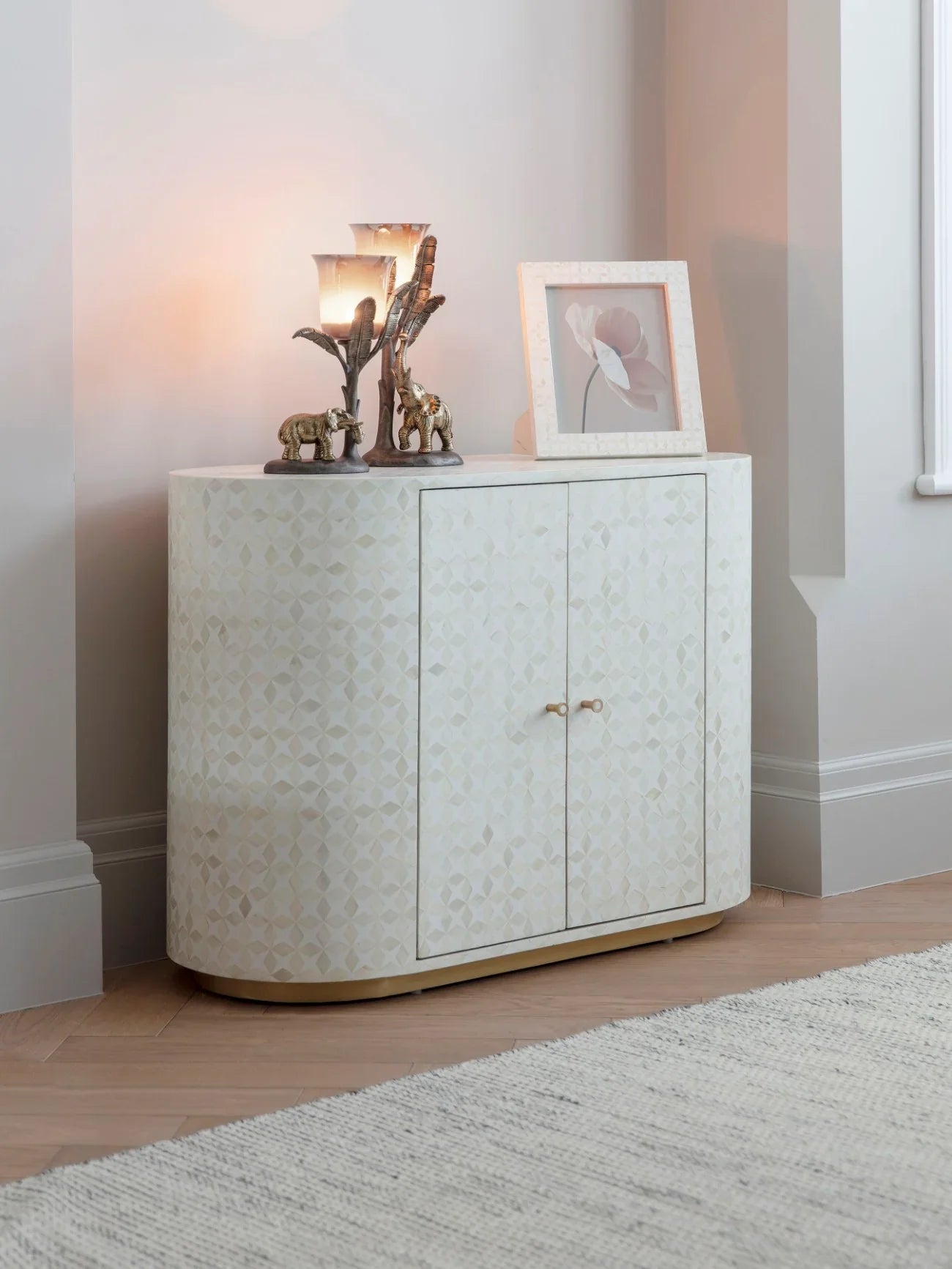Cream inlay cabinet in cozy room with decorative items on top.