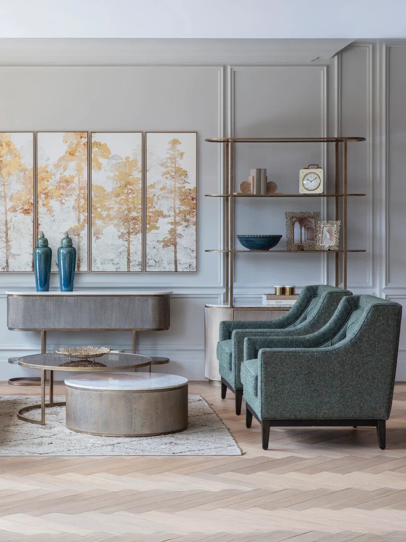Aged gold shelving unit in elegant living room with teal armchairs.