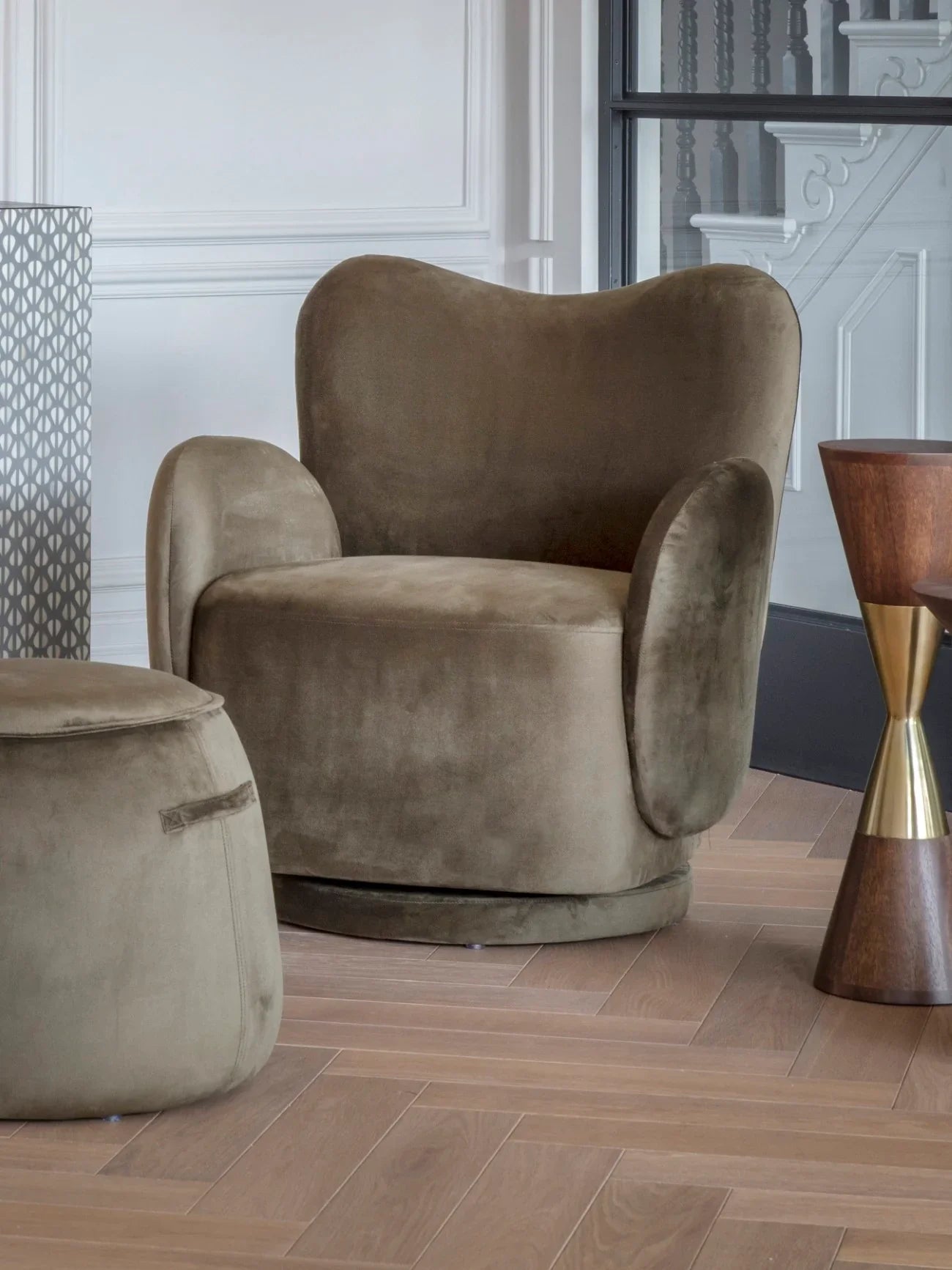 Velvet green swivel chair in elegant room with wooden floor and modern decor.