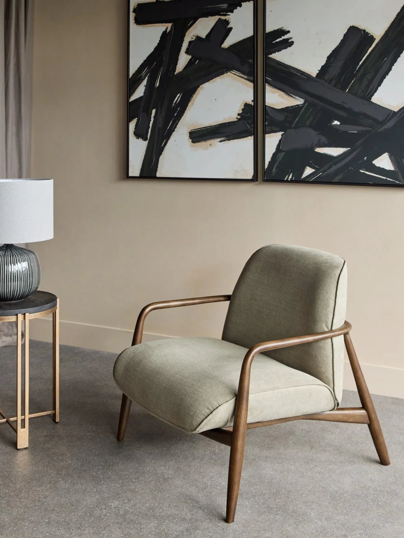 Green fabric chair with wooden arms in modern living room setting.
