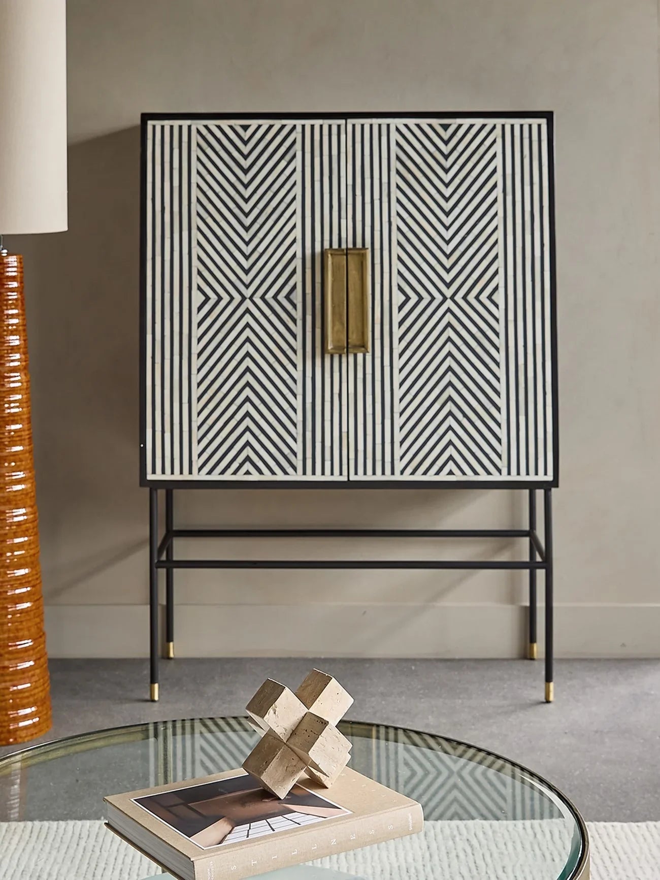 Geometric inlay cabinet in modern living room with glass coffee table.