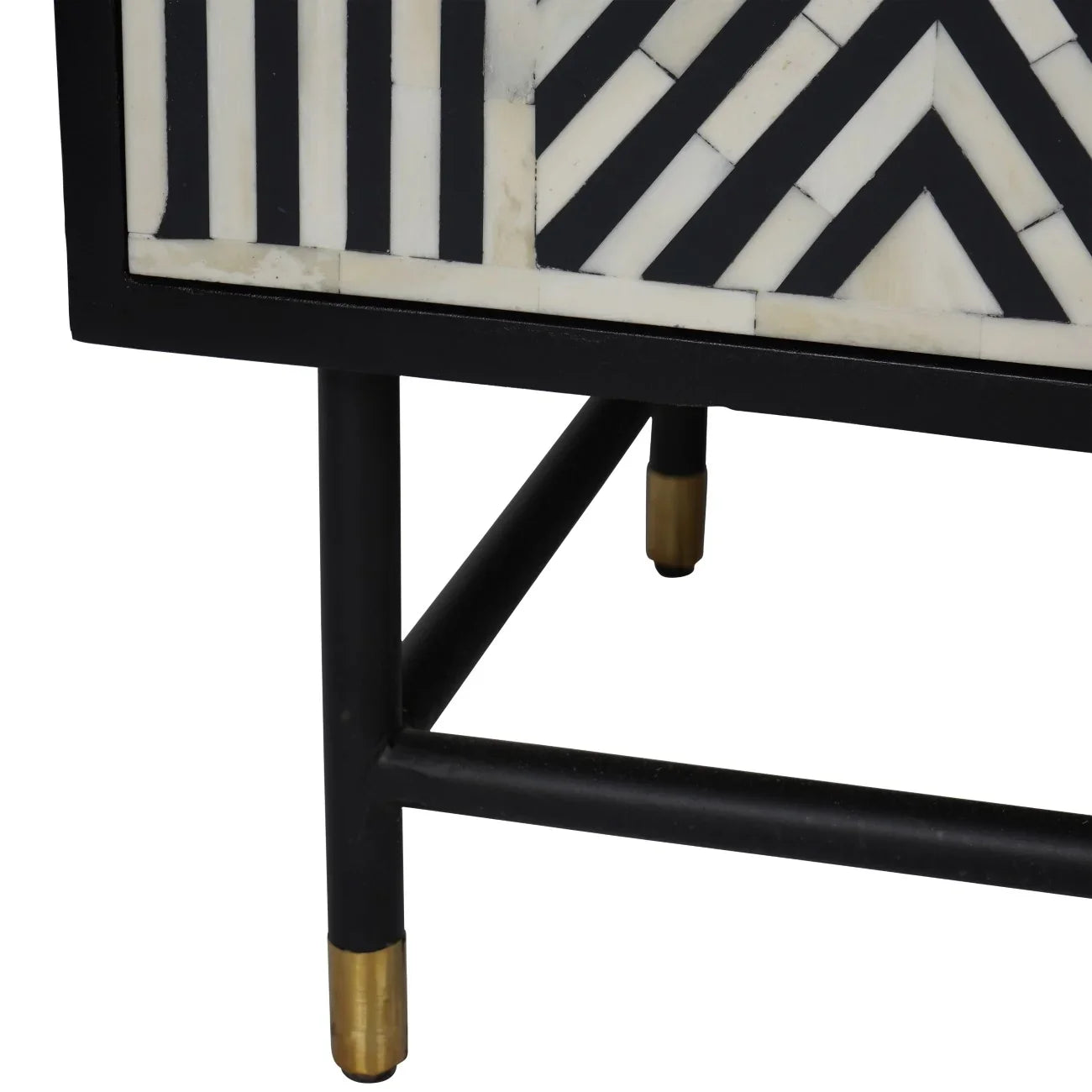 Black and white geometric pattern with gold-tipped legs on cabinet corner.