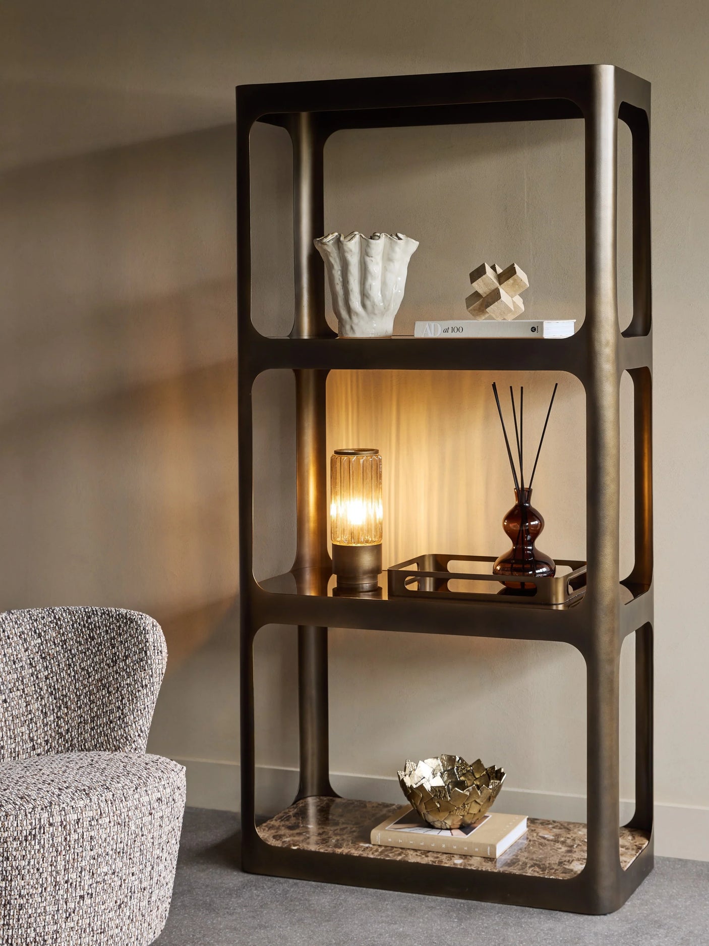 Smoked bronze shelving with decorative items in a cozy living room setting.