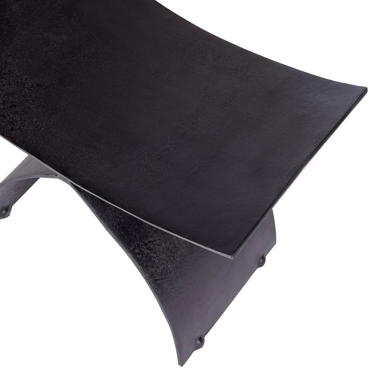 Curved black iron stool seat with textured surface detail.