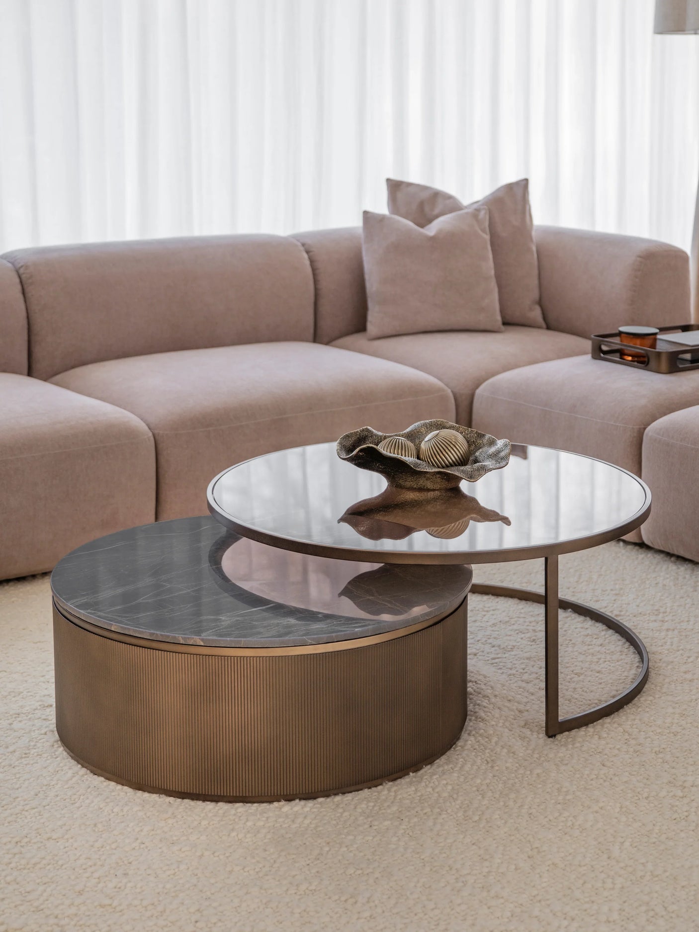 Gold nesting tables with glass tops in a cozy living room setting.