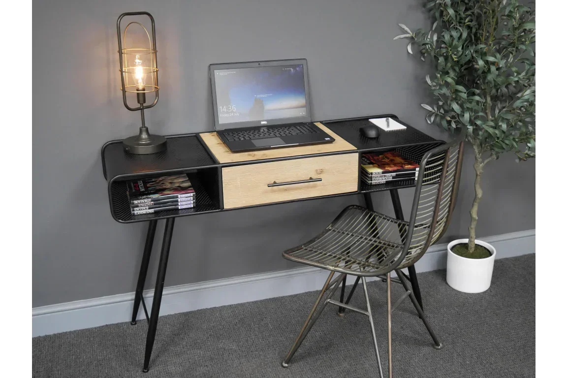 Black and wood home office desk with drawer, metal chair and table lamp against grey wall