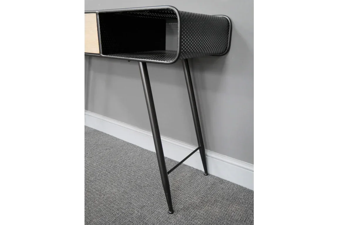 Black metal console table with textured finish and slim angled legs against grey wall