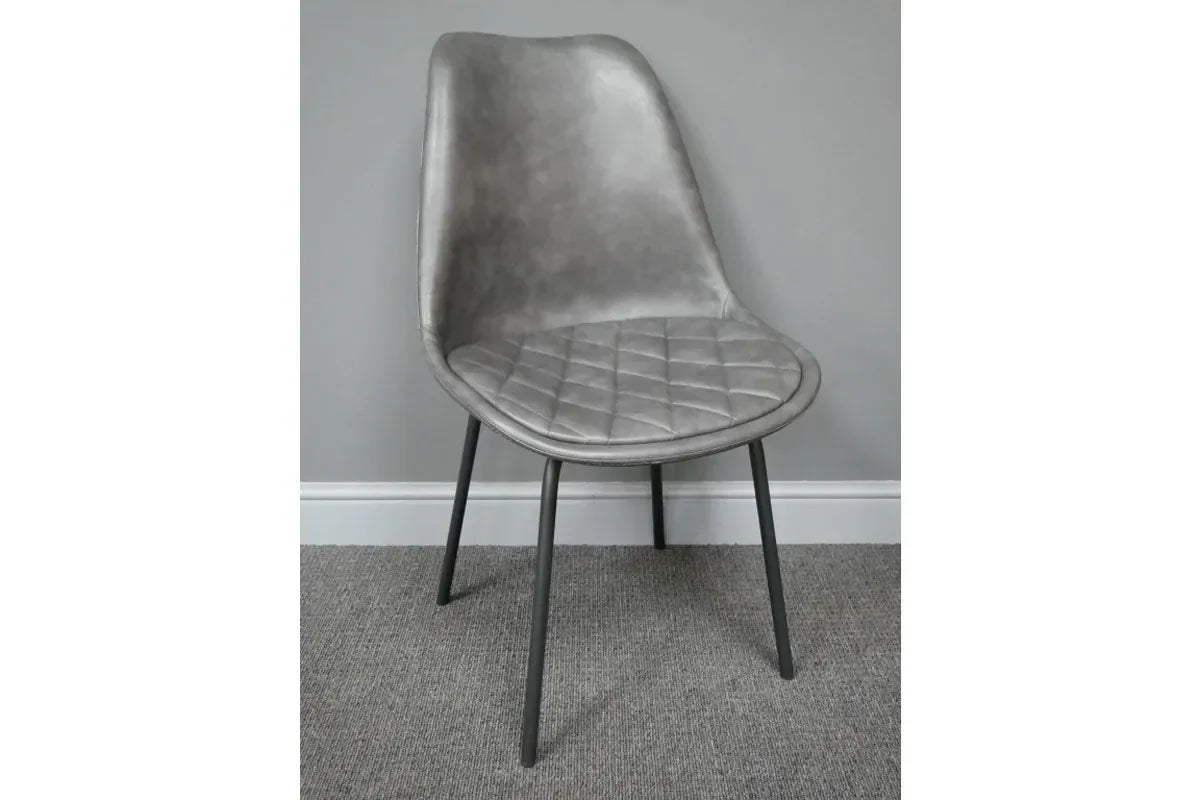 Grey faux leather dining chair with diamond-stitched seat and black metal legs