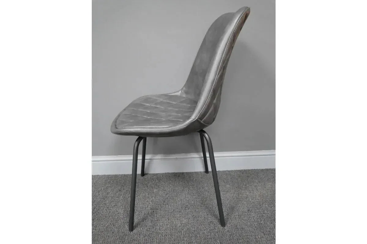 Grey dining chair with stitched faux leather seat and black metal legs side view
