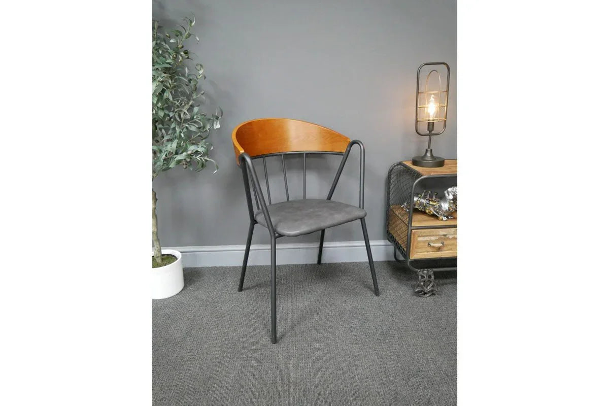 Modern dining chair with curved wood back, black metal frame, and grey padded seat
