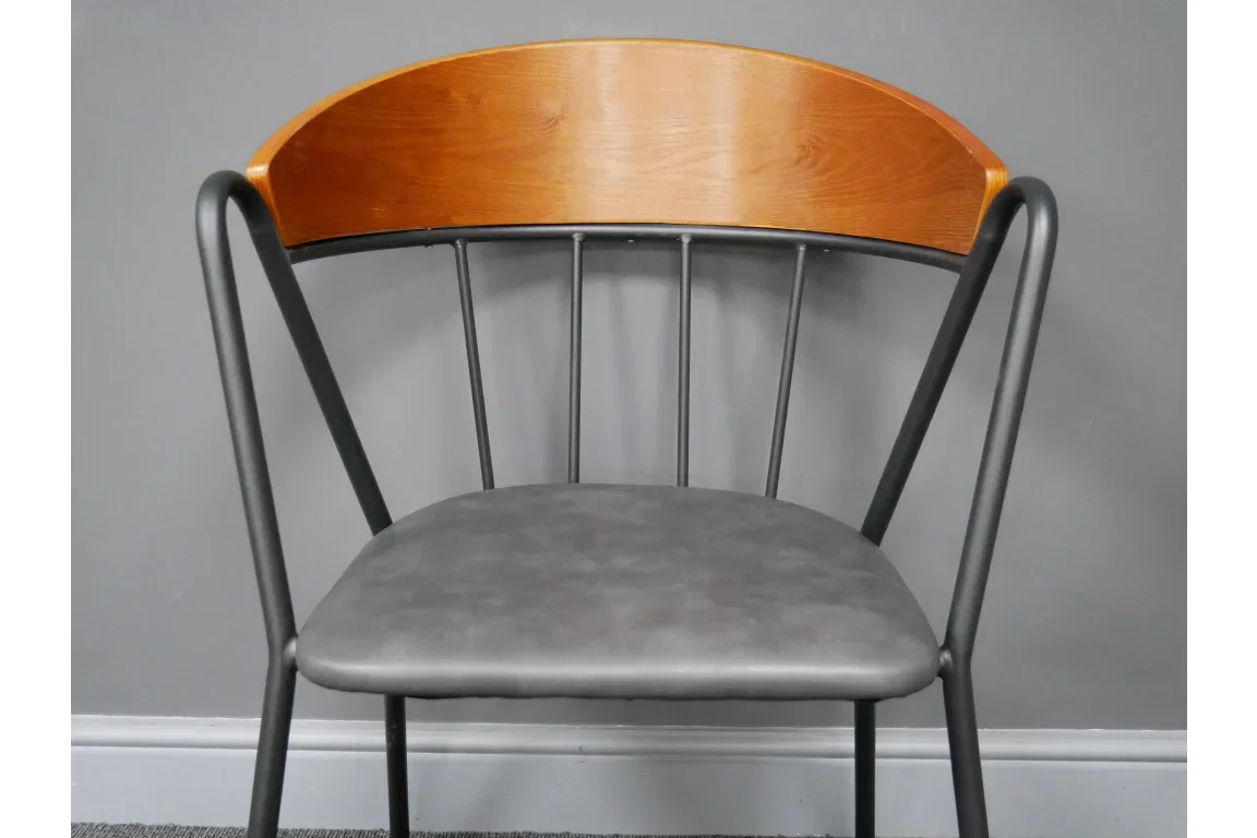 Modern dining chair with black metal frame, grey faux leather seat and curved wood backrest