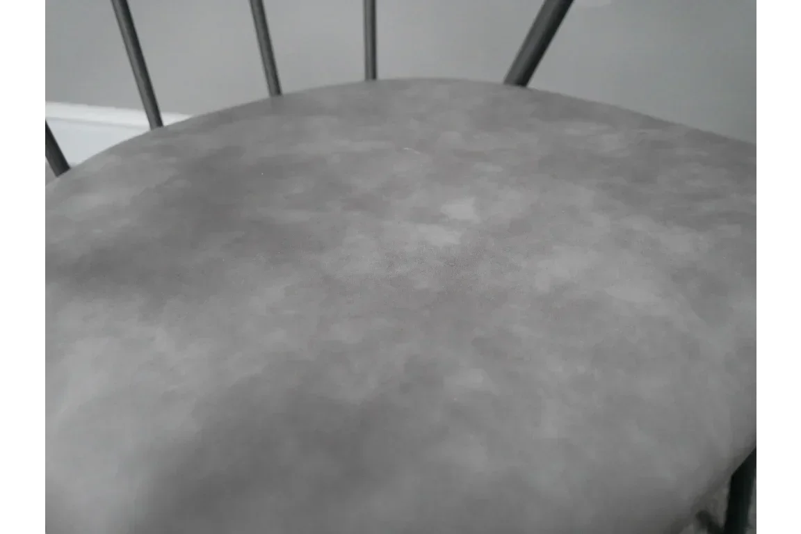 Close view of grey upholstered chair seat with black metal frame