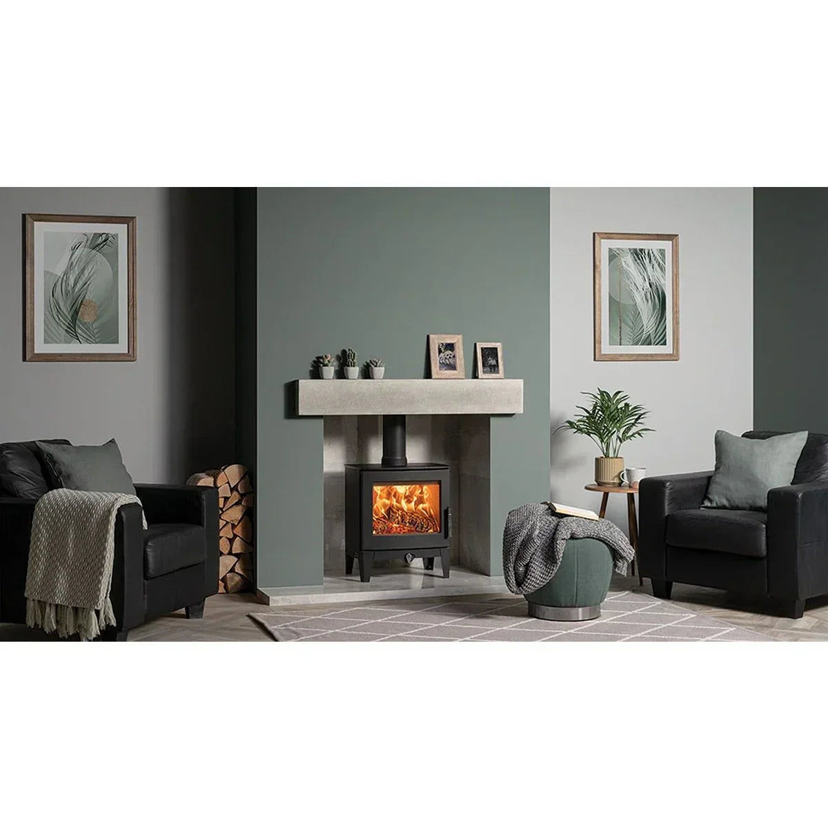Modern living room with wood burning stove, two black armchairs and green accent decor