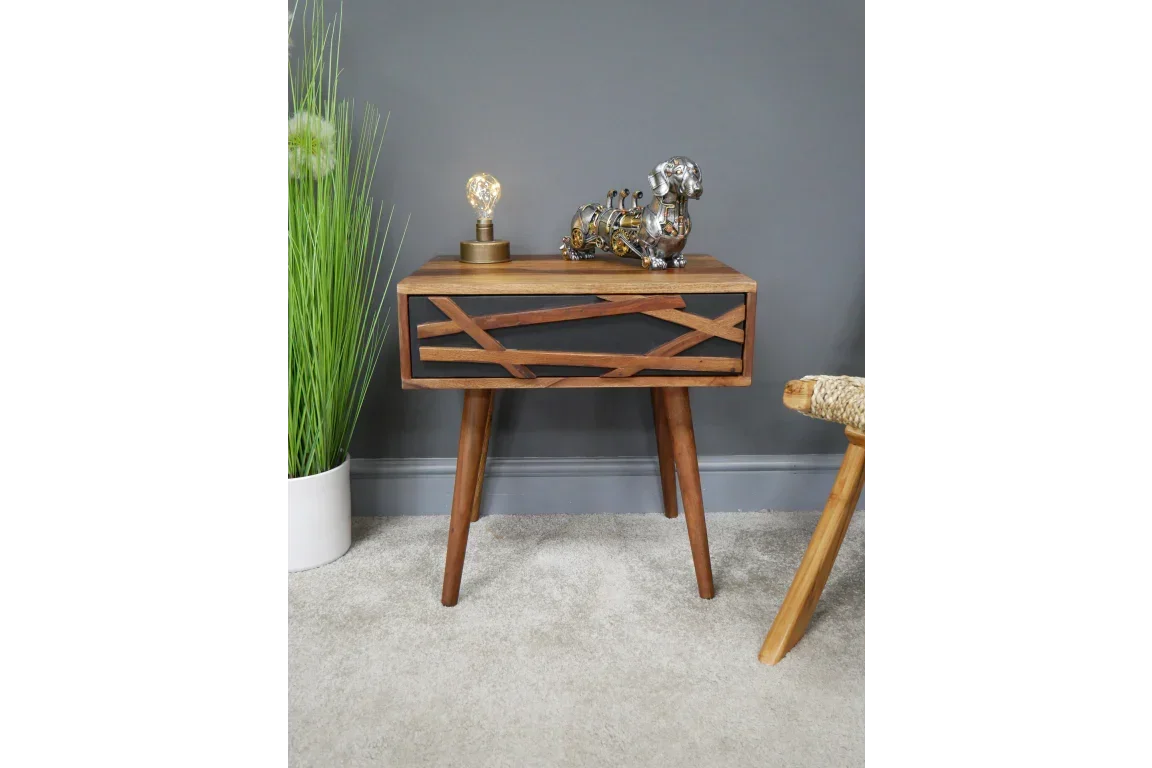 Modern wooden side table with drawer and decorative items in living room setting