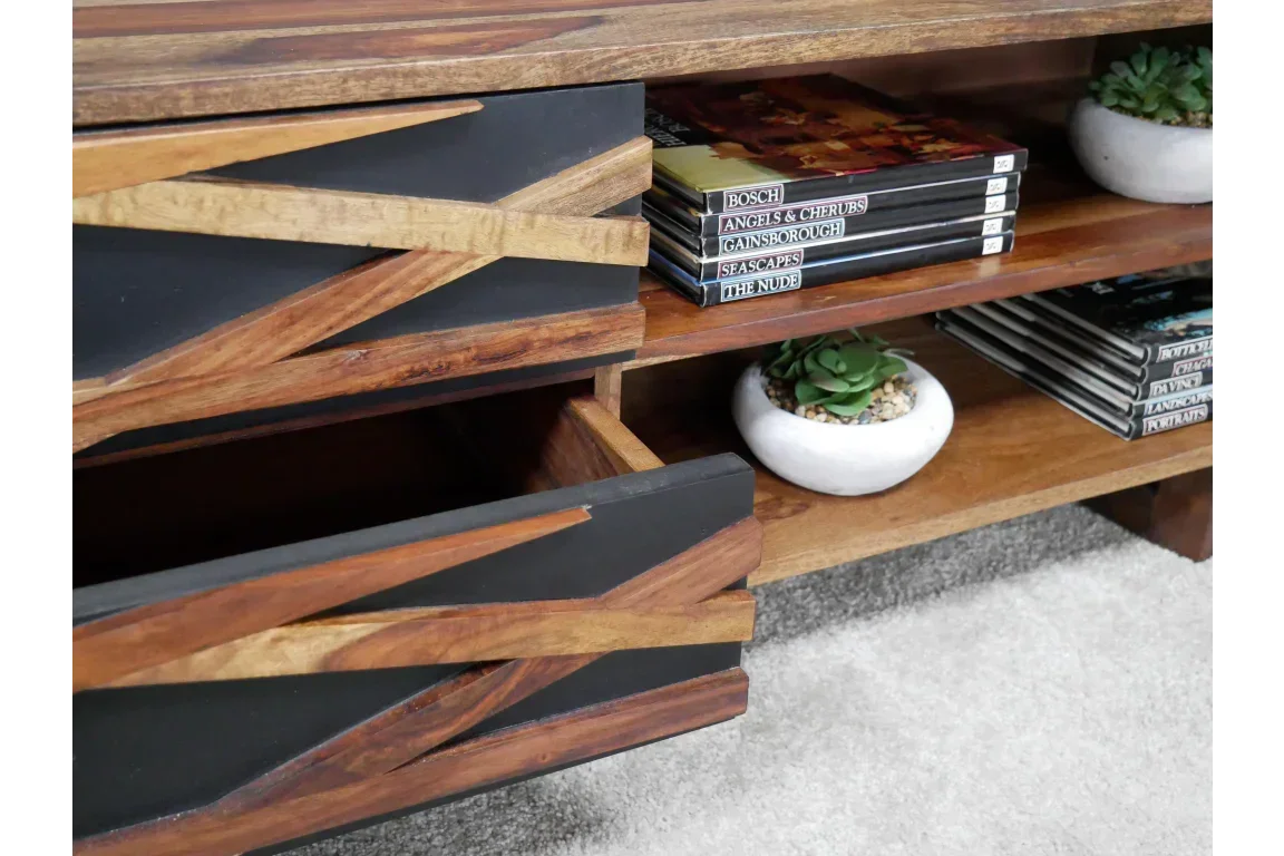Wooden TV unit with black geometric drawers, open shelves holding books and small succulent plants