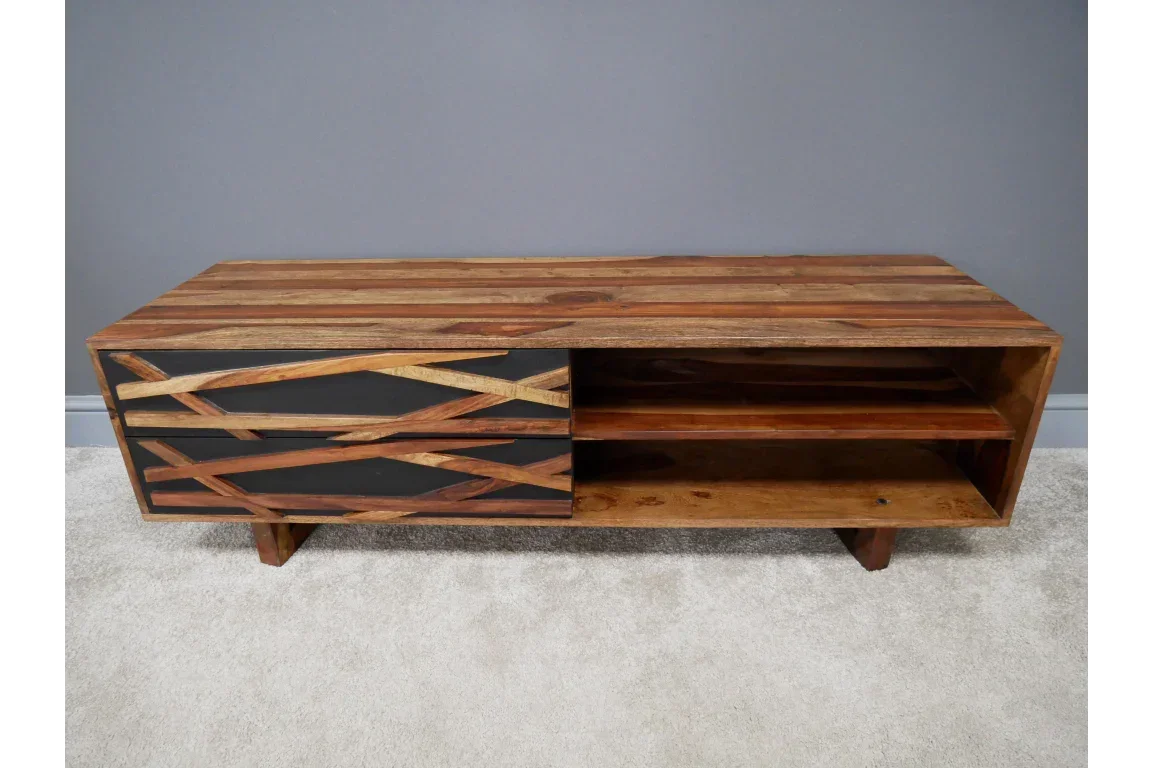 Wooden TV unit with black geometric pattern drawers and open shelving on light carpet