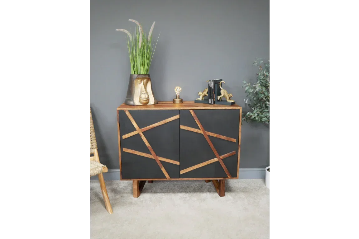 Modern black and wood sideboard with geometric pattern, styled with gold decor and houseplant