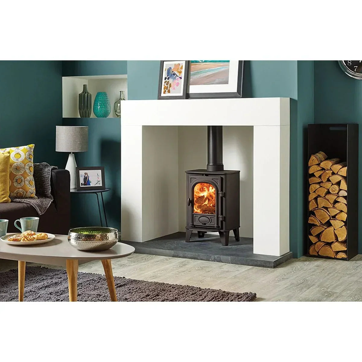 Black wood burning stove in modern living room with fireplace and log storage