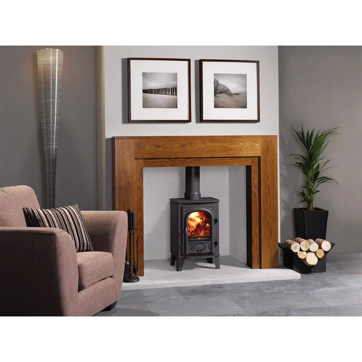 Wood burning stove with oak fireplace surround, armchair, and log holder in modern living room