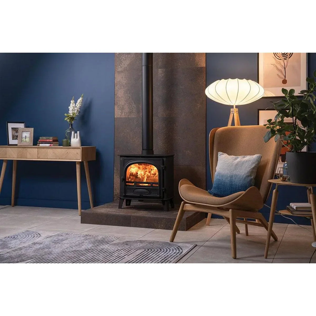 Modern living room with wood burning stove, accent chair, console table and floor lamp