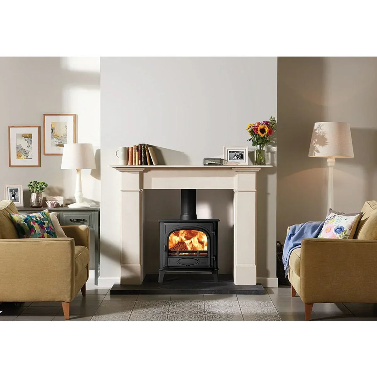Living room with beige sofas, wood burning stove and stone fireplace surround