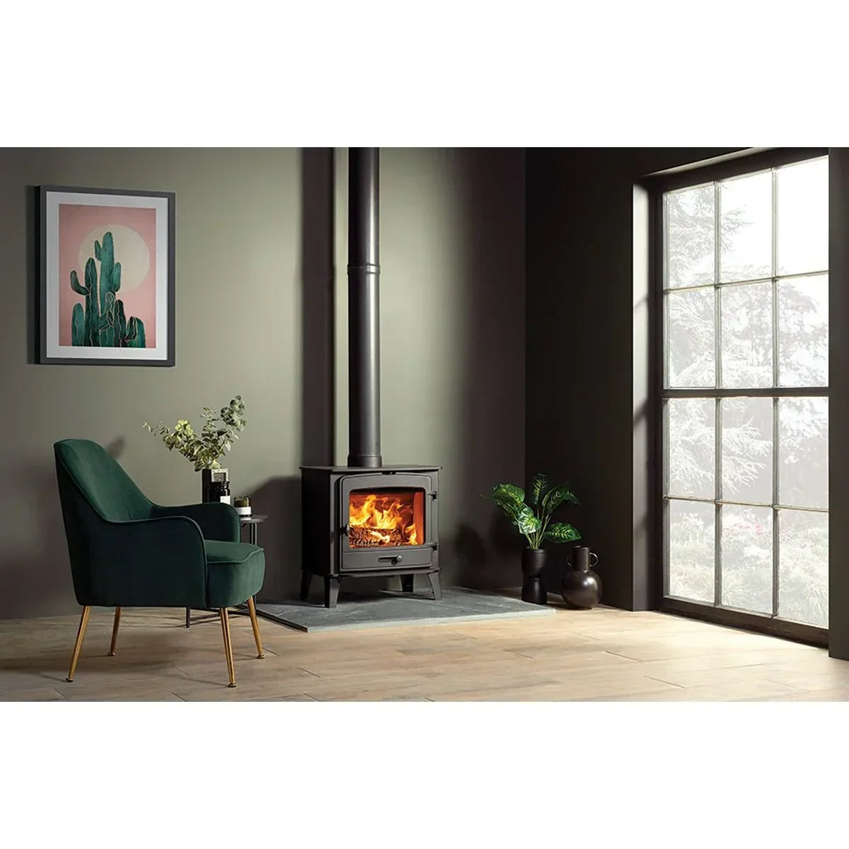 Modern wood burning stove with fire in cosy living room, green armchair, large window