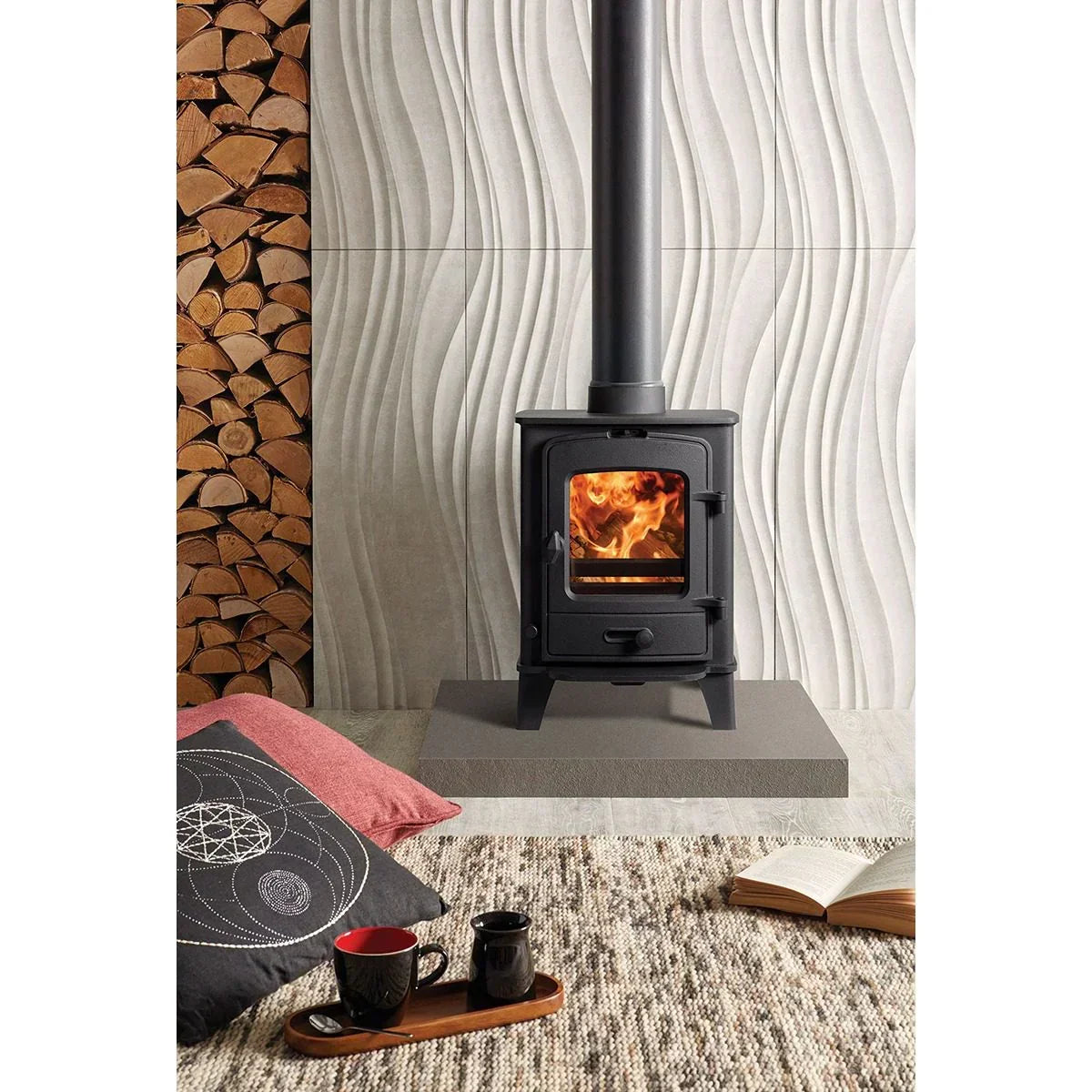 Black wood burning stove with fire, stacked logs, textured wall and cosy living room setting