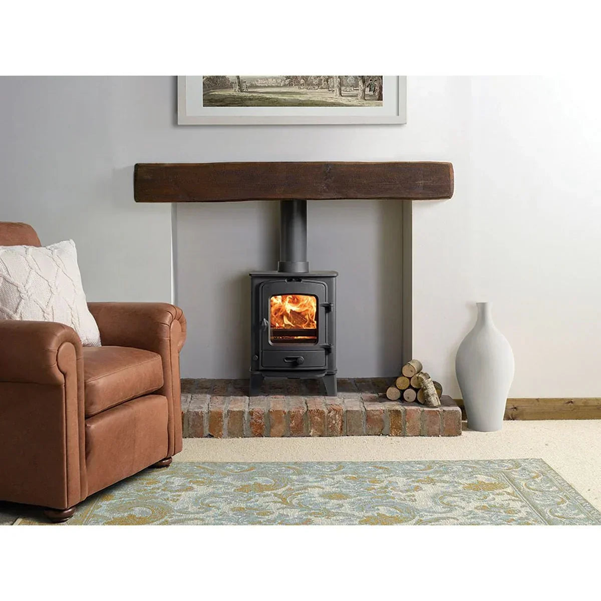 Wood burning stove on brick hearth with log pile, brown armchair and patterned rug