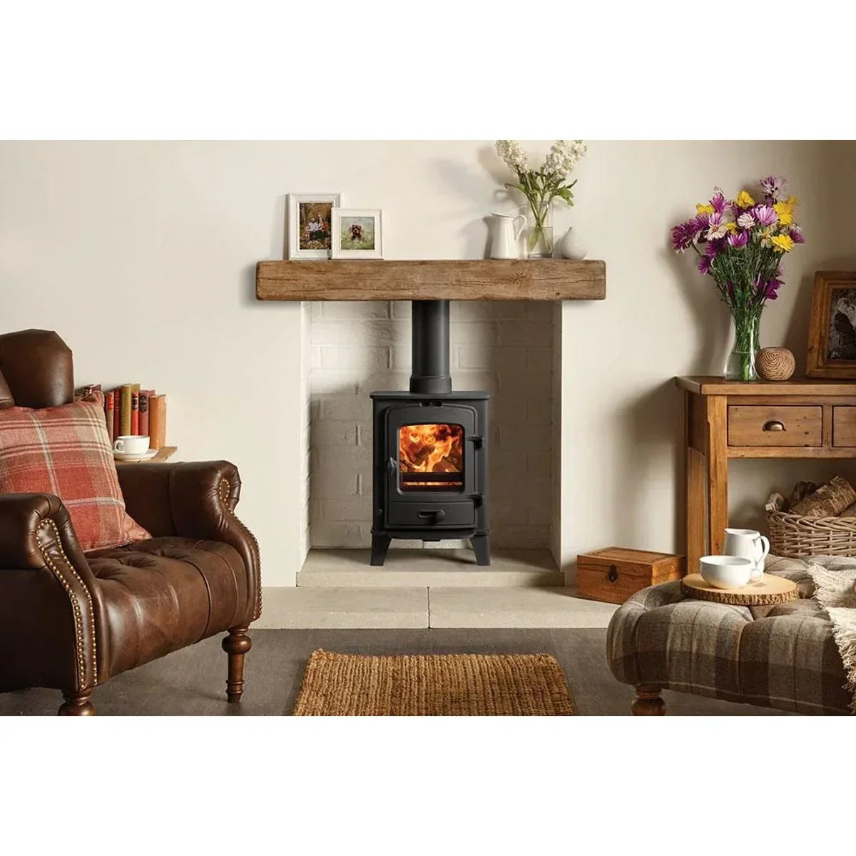 Black wood burning stove with glass door in cosy living room fireplace