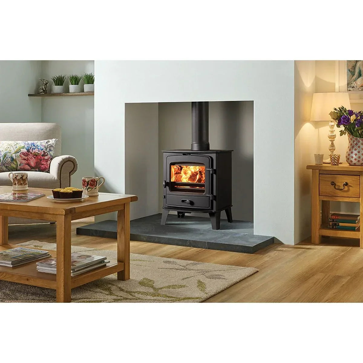 Black wood burning stove with glass door in modern living room with oak furniture