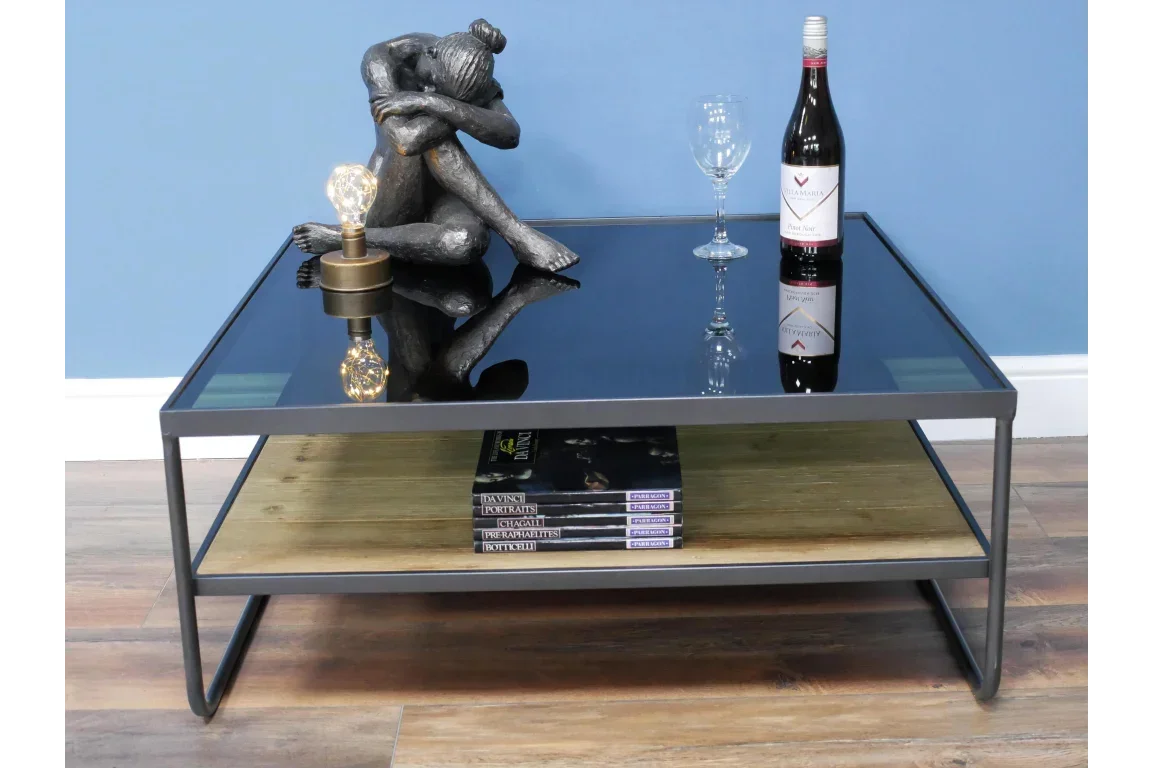 Black glass coffee table with metal frame, wooden shelf, wine bottle and decorative figurine