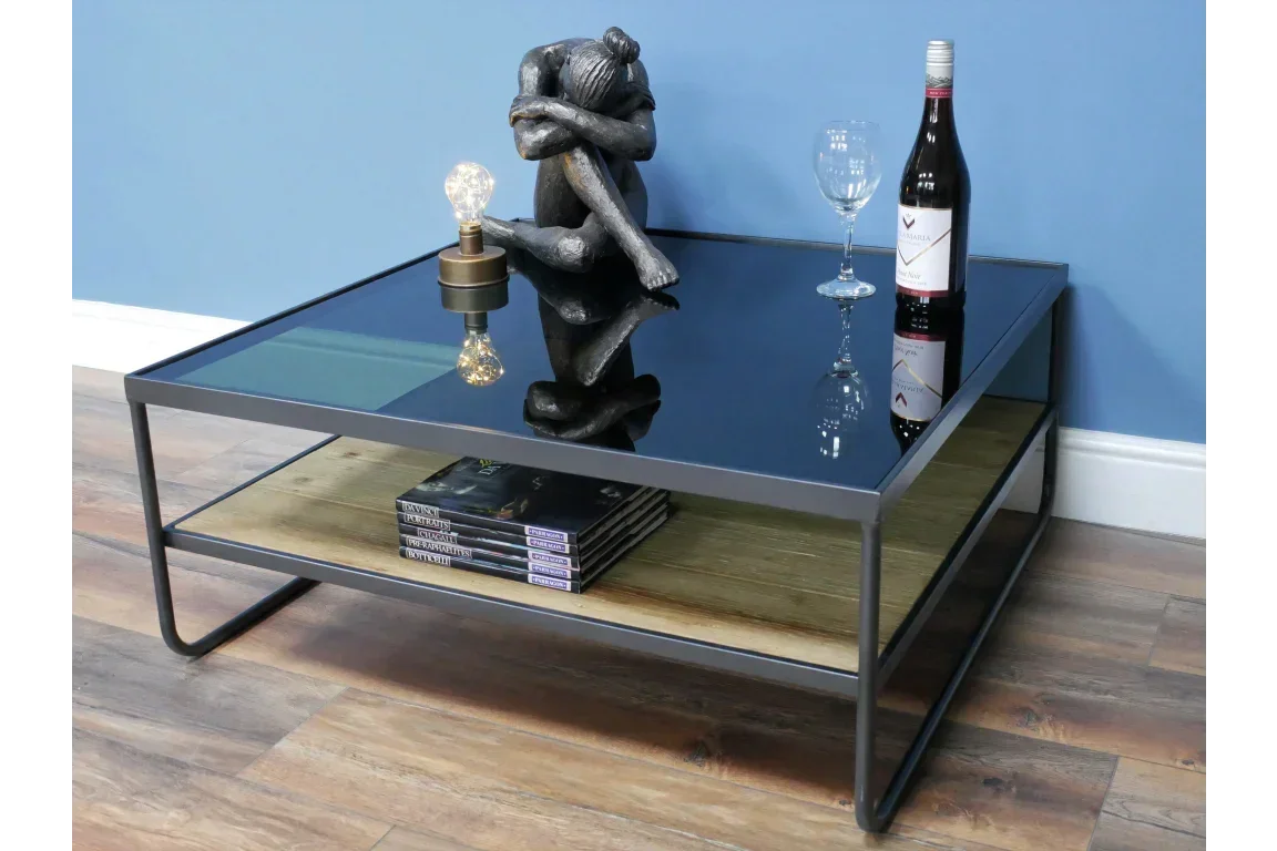 Black glass coffee table with metal frame, wood shelf, wine bottle, and decor accents