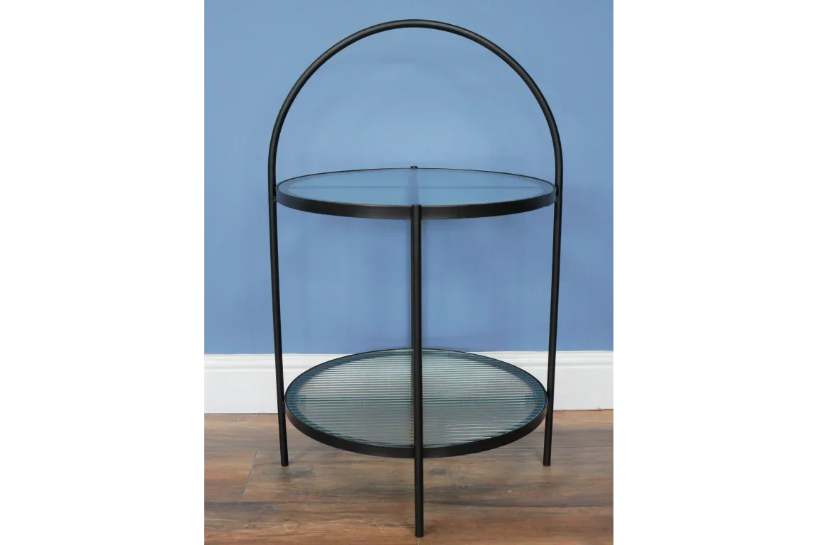 Round glass side table with black metal frame and arched handle, two-tier design