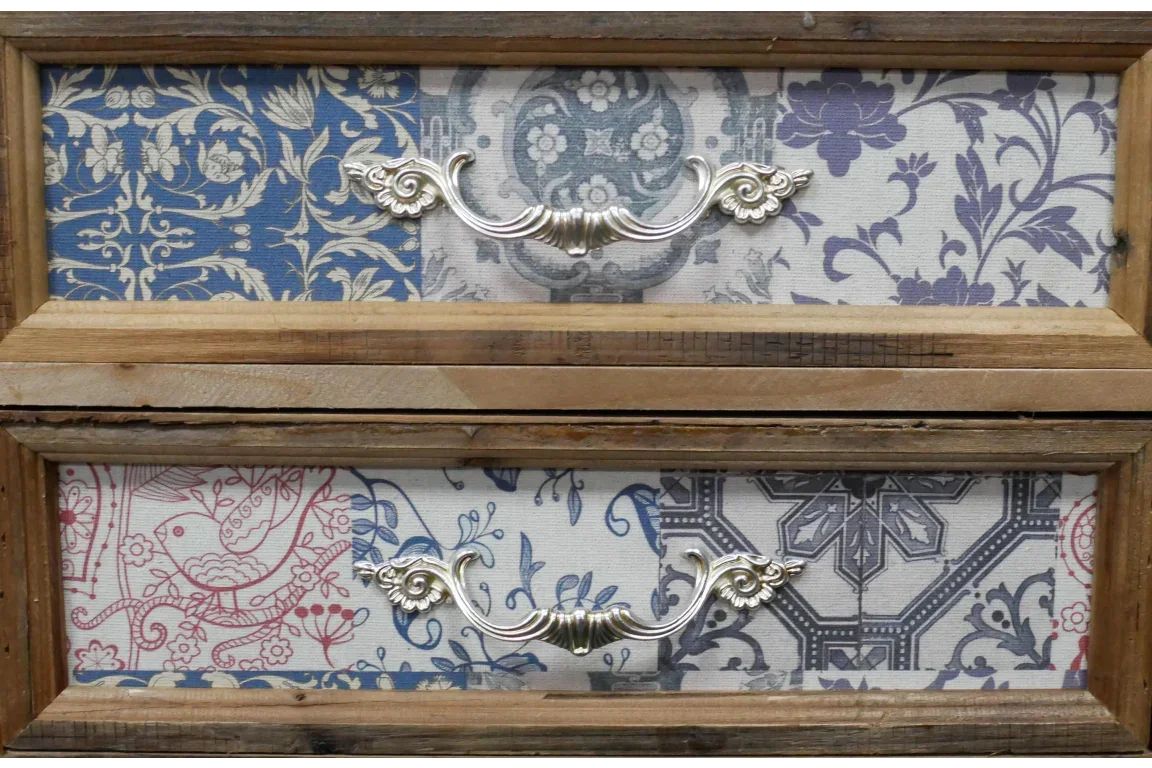 Vintage wooden drawer front with ornate metal handles and multicolour floral patterns