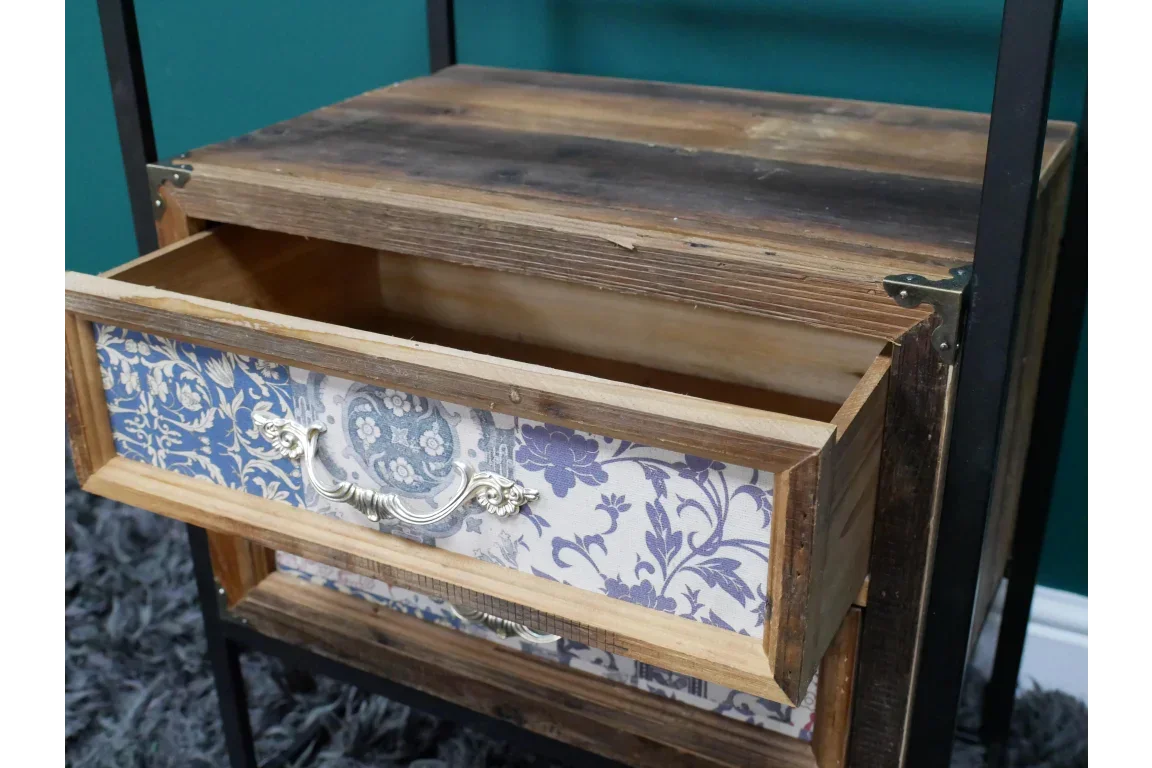 Rustic wood bedside table with an open floral patterned drawer and vintage metal handle