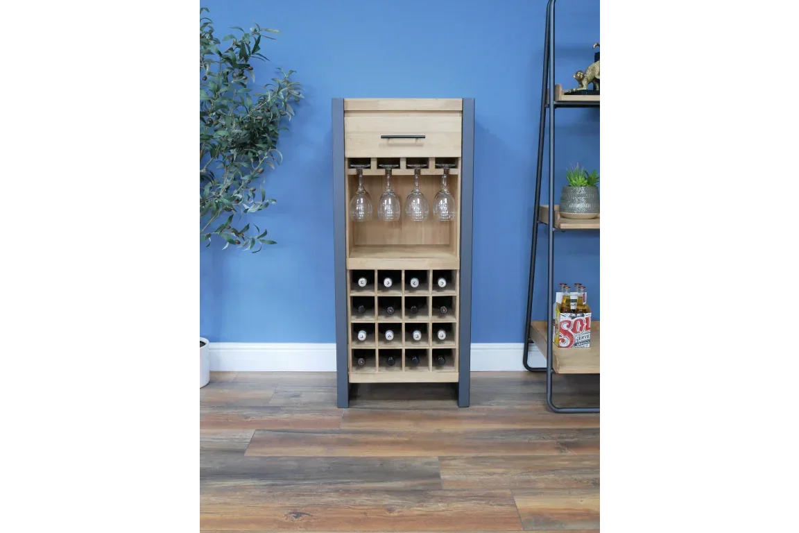 Wooden wine rack cabinet with glass holder and drawer against blue wall on wooden floor