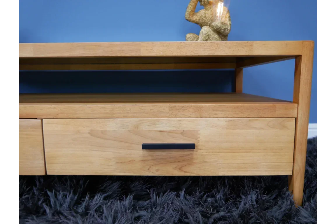 Oak wood coffee table with drawer, open shelf and black handle on shaggy rug
