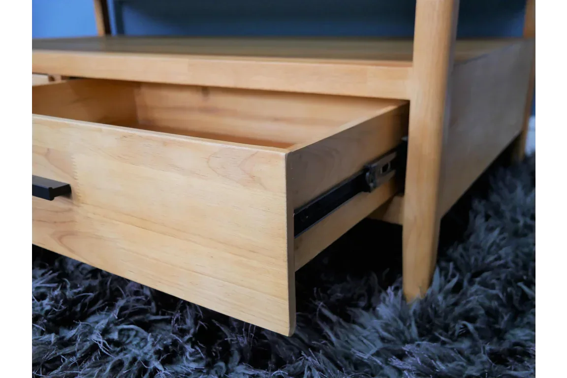 Light wood coffee table with open drawer and black handle on grey rug
