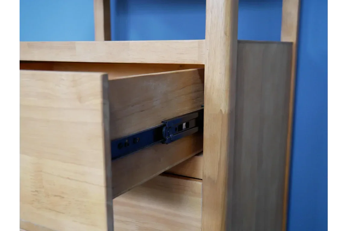 Closeup of wood drawer with metal runners in a light oak chest of drawers