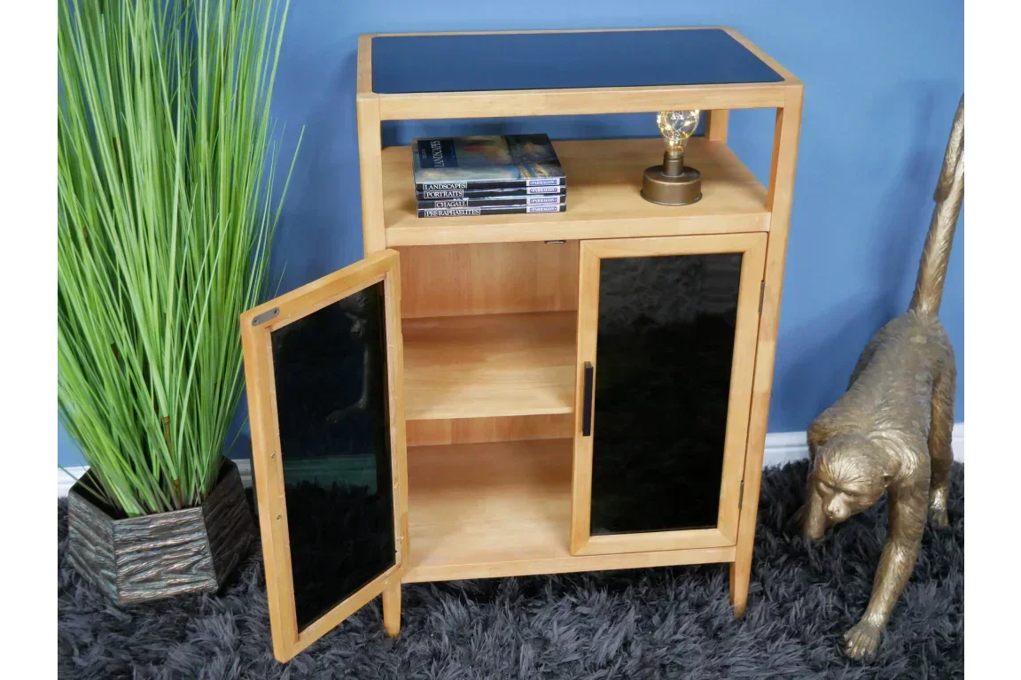 Oak sideboard cabinet with black glass doors, open shelving, books, and lamp on display