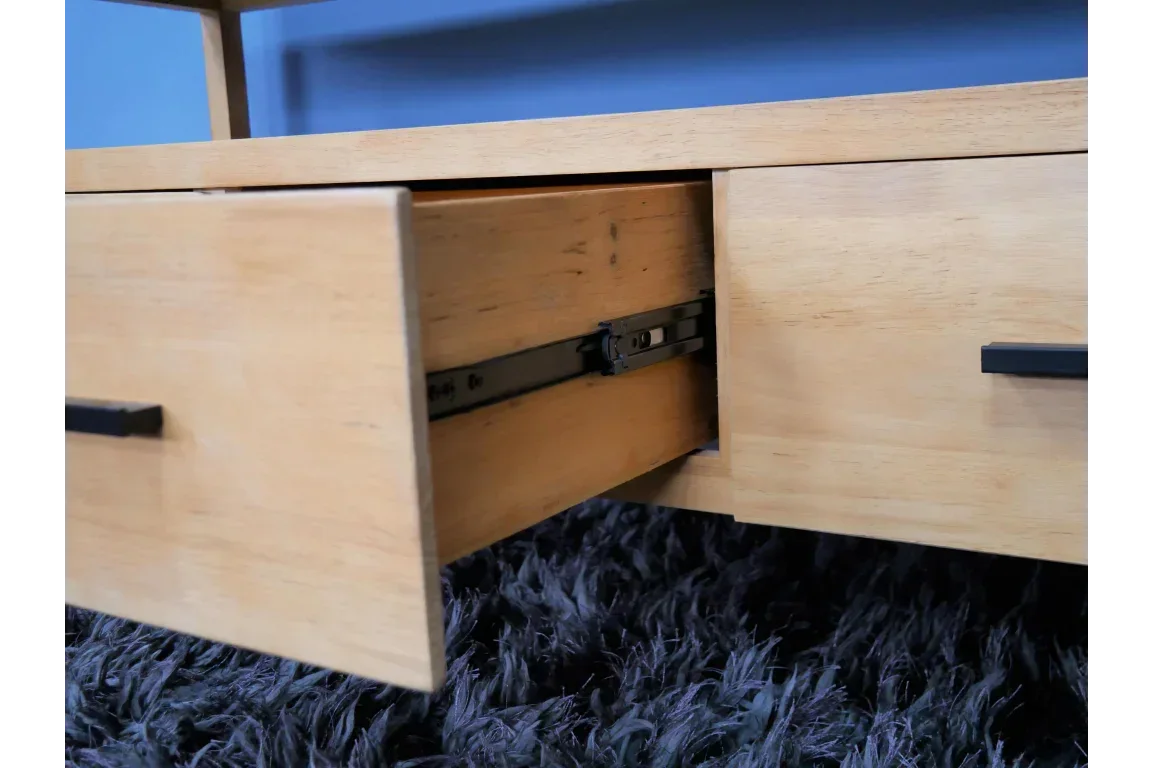 Light wood cabinet drawer with black metal handle, shown open on a dark textured rug
