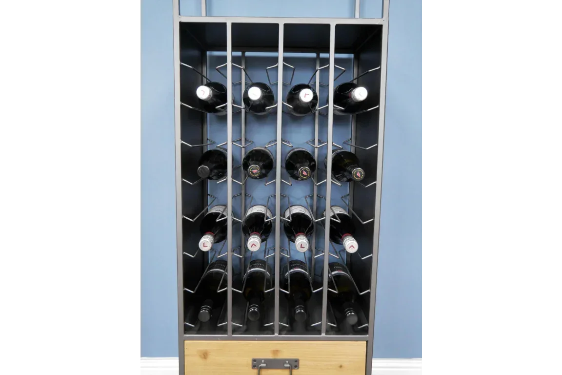 Metal wine rack with wooden drawer, holding wine bottles against blue wall and white skirting