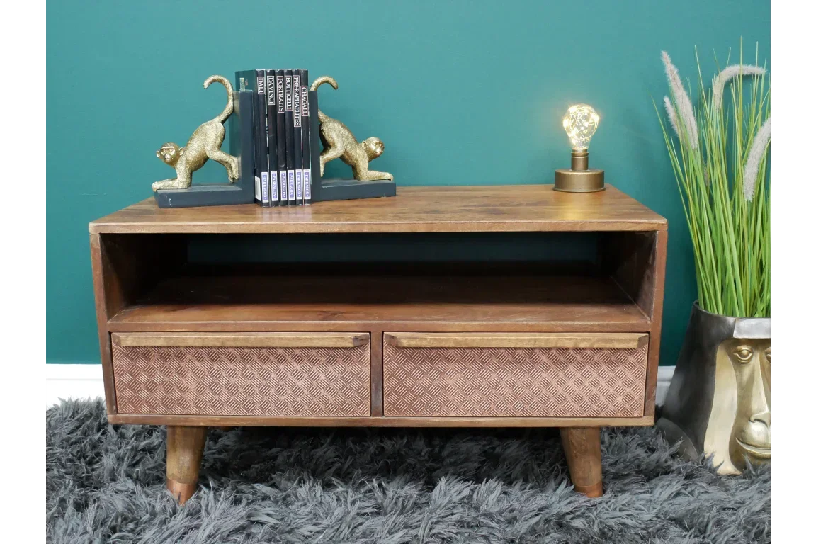 Wooden TV unit with two patterned drawers, open shelf, gold lamp, and monkey bookends
