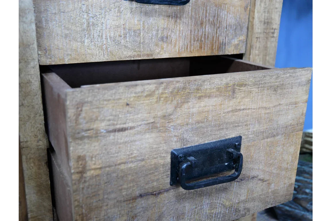 Rustic wooden chest of drawers with black metal handles, close-up of open drawer