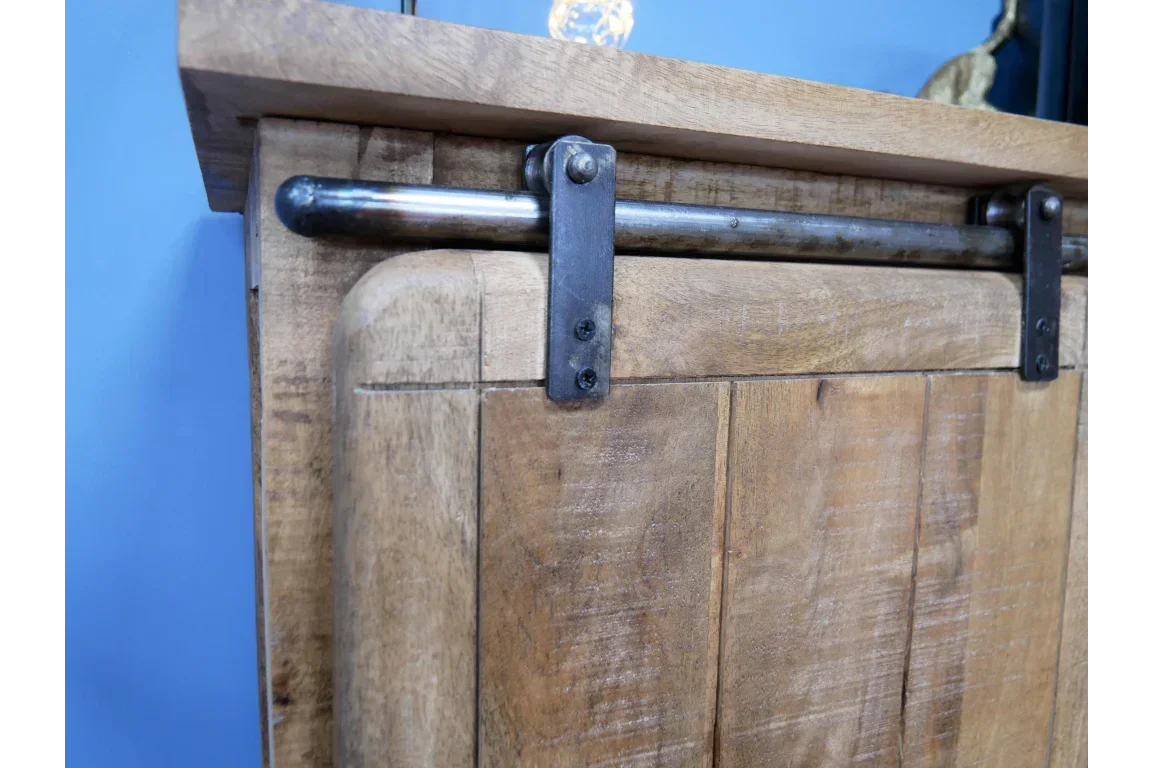 Closeup of wooden sliding barn door with metal rail and hardware, natural wood cabinet finish