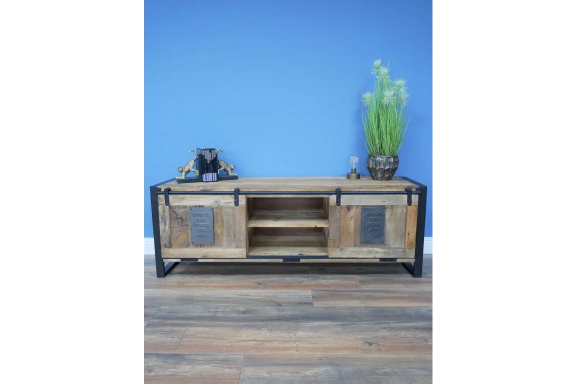 Rustic wood and metal TV unit with sliding doors and decorative shelving, blue wall backdrop
