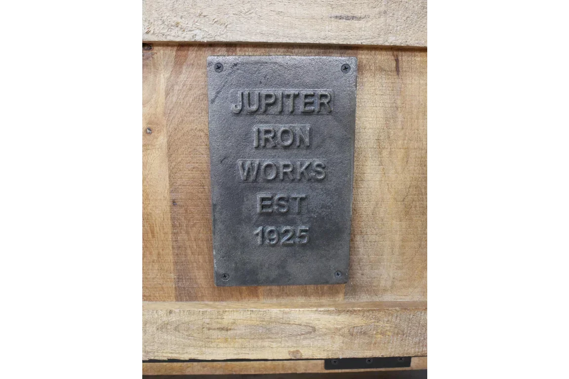 Industrial iron works plaque on rustic wood furniture panel, black metal with embossed text
