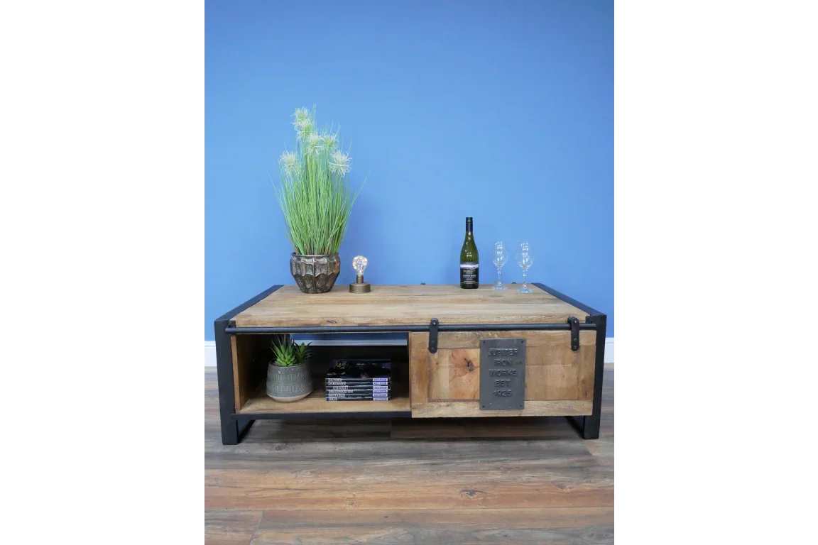 Rustic wood coffee table with metal frame, sliding door, and shelving on wooden floor